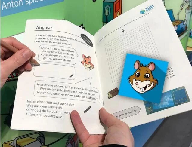 Das Foto zeigt aufgeschalgene Arbeitsmaterialien mit Texten, die von H&auml;nden betrachtet und besprochen werden.