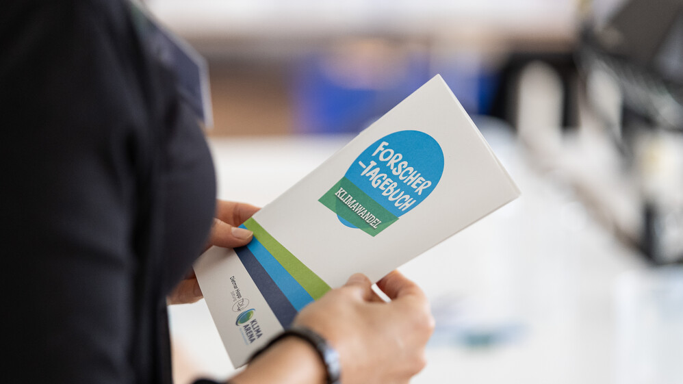 Nahaufnahme des Forschertagebuchs, wo Ergebnisse von Experimenten festgehalten werden.