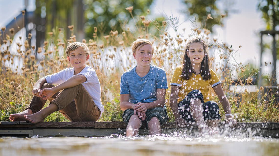 Gruppe Jugendlicher am Teich der Klima Arena